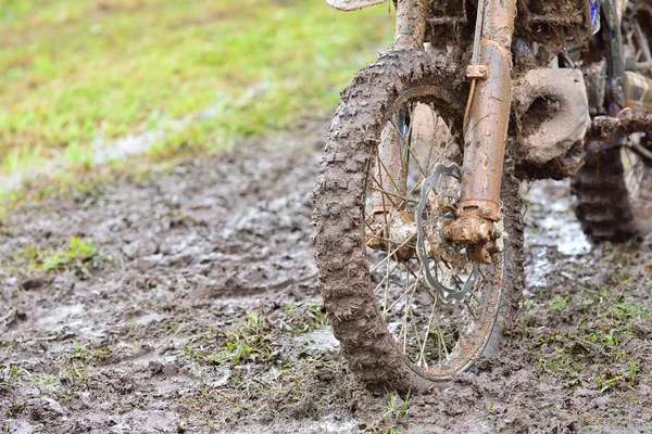 Dirty wheel of motocross bike in mud. Bokeh.