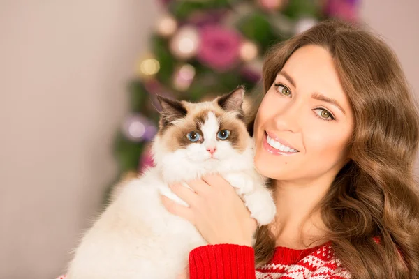 Christmas party, winter holidays woman with cat. New year girl. christmas tree in interior background.