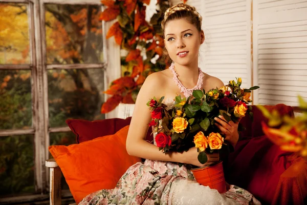 Young woman in vintage dress on autumn porch. Beauty  girl in fa