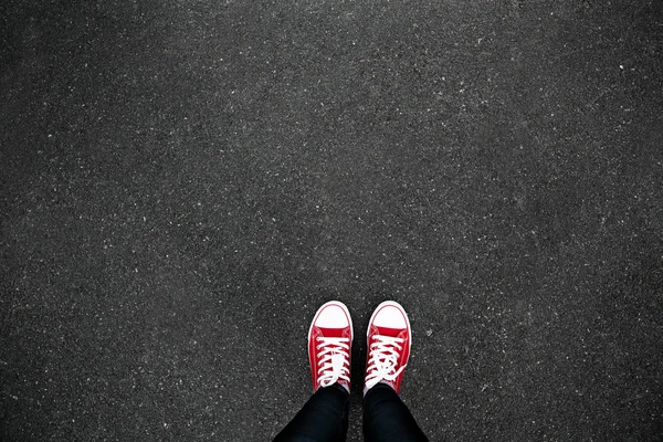 Gumshoes on urban grunge background of asphalt. Conceptual image