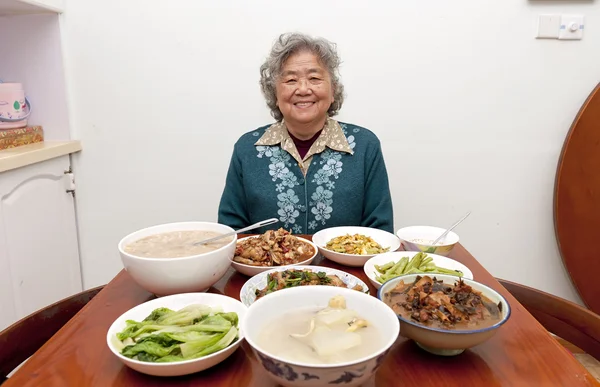 Sitting at the dinner table, happy grandmother