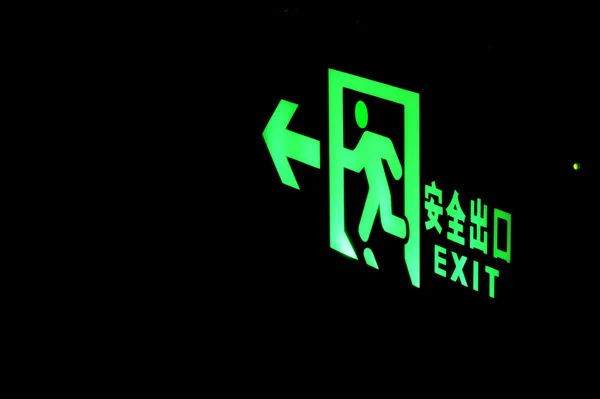 Emergency exit sign shine bright green light in darkness