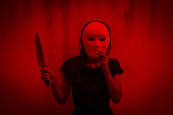 Mysterious woman in black dress wearing white mask with knife