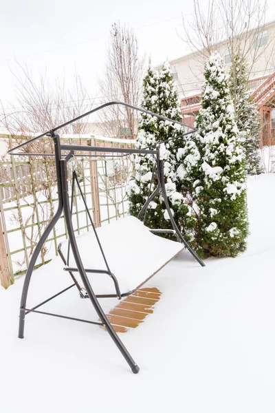 Snowy swing on garden patio, winter scenery