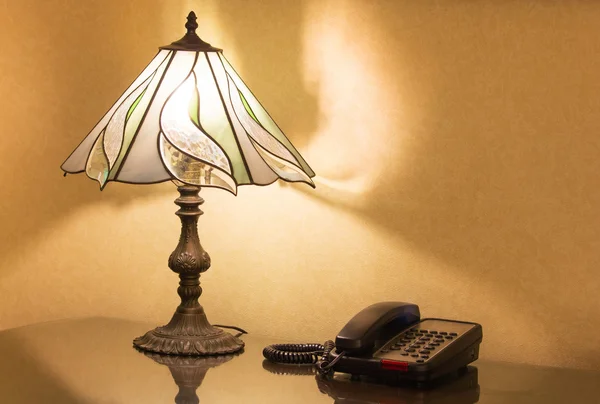 Table lamp and phone on desk