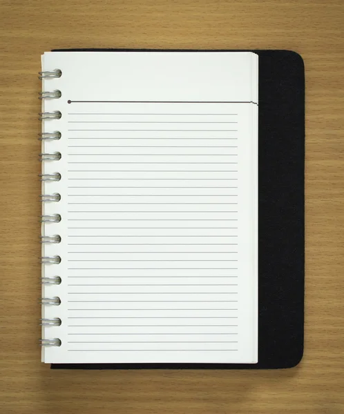 Blank spiral notepad on wood background
