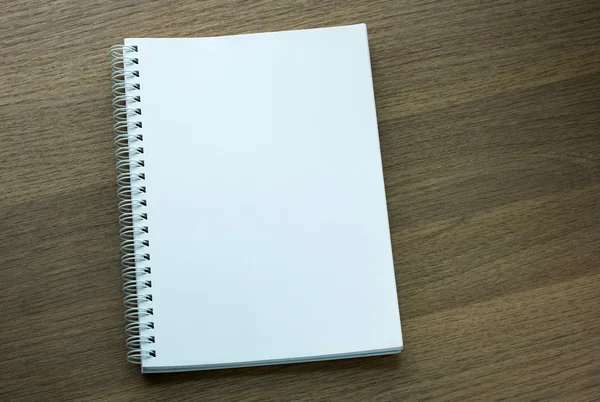 Blank spiral notebook on dark wood background