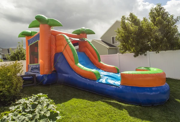 Inflatable bounce house water slide in the backyard