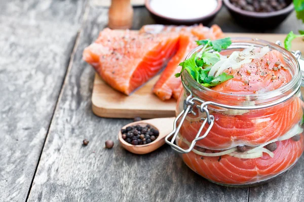 Salted  salmon in glass jar on an old wooden table