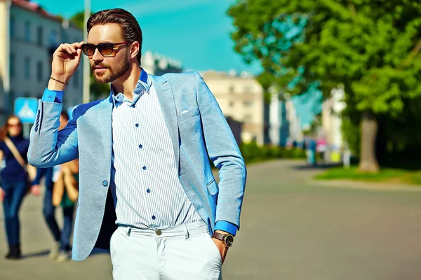 High fashion look.Young stylish confident happy handsome  businessman model man in blue suit cloth lifestyle in the street in sunglasses