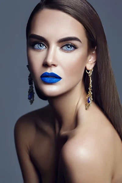 Sensual glamour portrait of beautiful  woman model lady with colorful makeup with blue lips  and jewelry