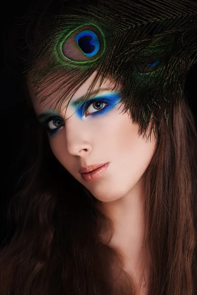 Beautiful Woman. Face with Makeup and Peacock Feather