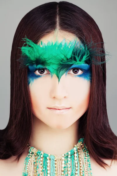 Yound Woman Fashion Model. Face with Makeup and Feather