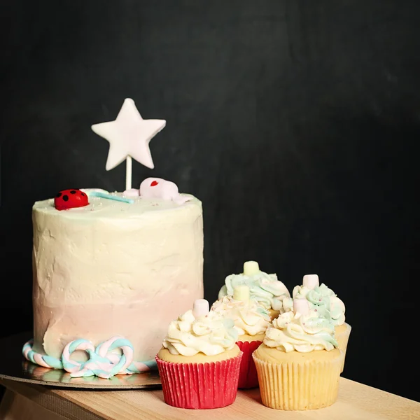 Birthday Cake and Cupcakes on Blackboard Background