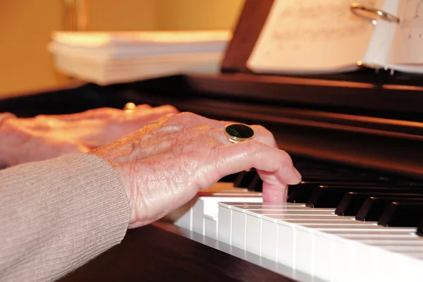 Close on Senior\'s hands playing piano