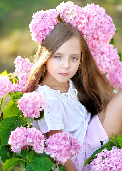 Portrait of little girl with flowers hydrangea