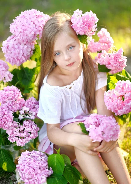 Portrait of little girl with flowers hydrangea