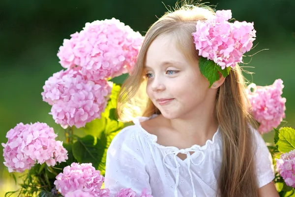 Portrait of little girl with flowers hydrangea