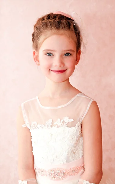 Adorable smiling little girl in white princess dress