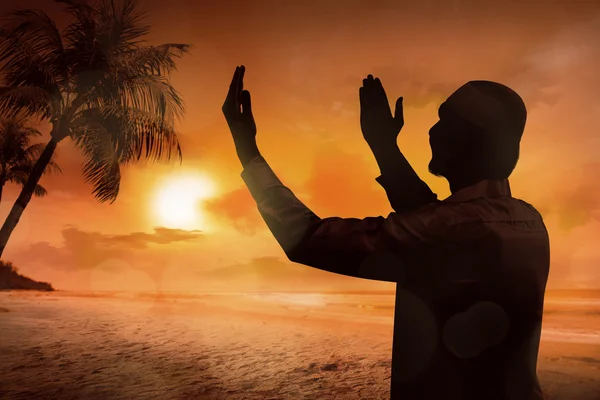 Silhouette of young muslim man praying