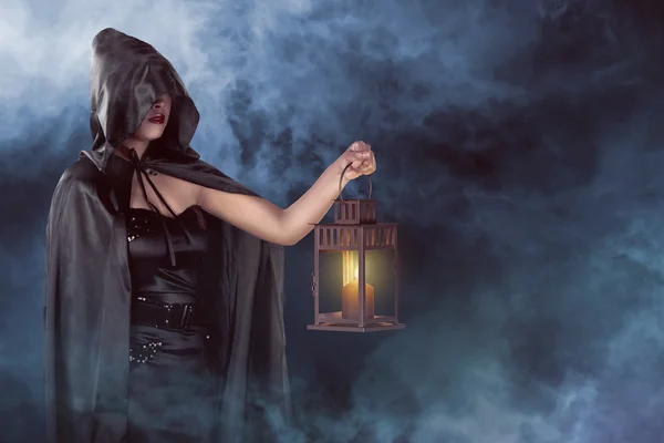 Halloween witch woman holding lantern