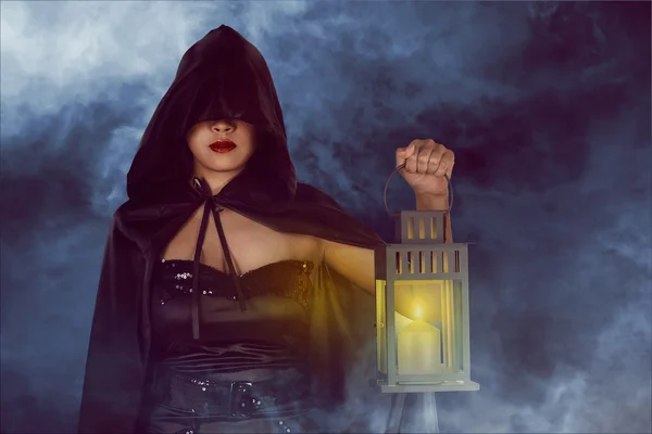 Halloween witch woman holding lantern