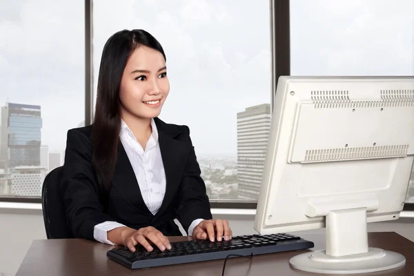 Smiling happy woman using computer