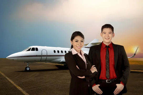 Business man and woman in front of private jet