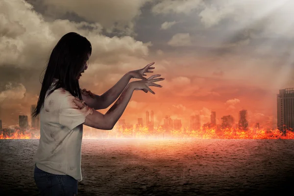 Scary female zombie with burning city background