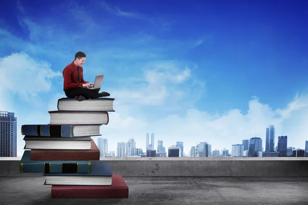 Business person working with laptop on  the top of books