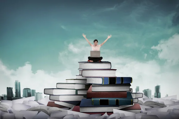 Business person working with laptop sit on top of book