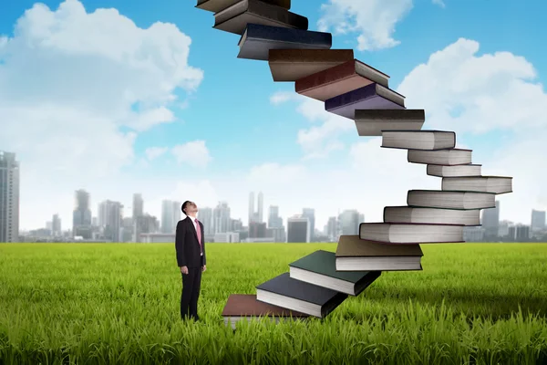Business person step up flying book that look like stair