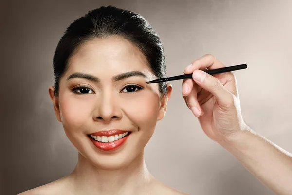 Beautiful asian woman doing makeup