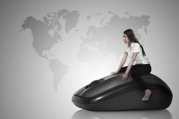 Business person riding computer mouse