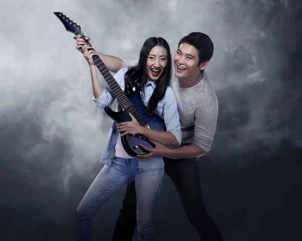 Lovely asian couple playing guitar