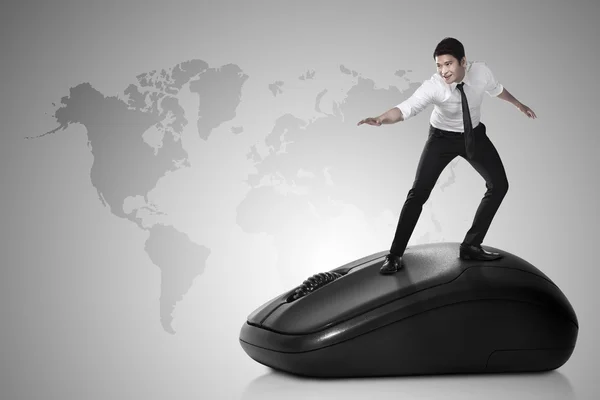 Businessman surfing on computer mouse
