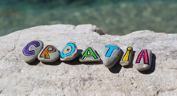 Croatia inscription, painted stones on the rock, adriatic sea in the background