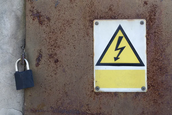 Old rusty metal door and padlock and warning attention sign board and empty space to your own text