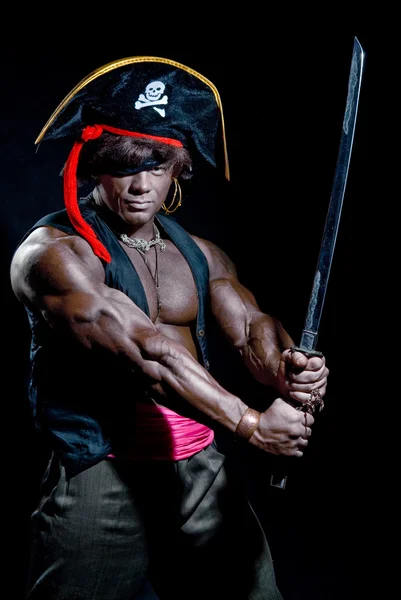 Muscular black man in a pirate hat and sword on a black backgrou