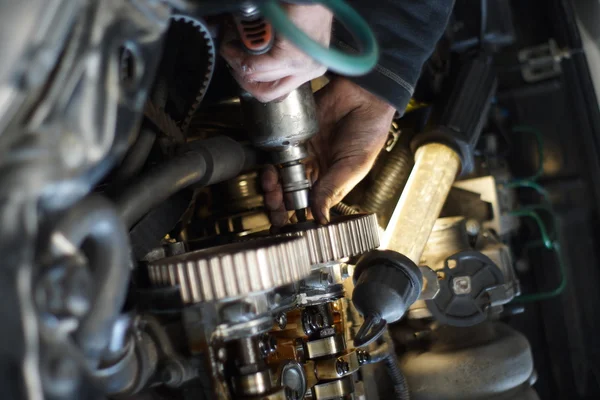 Dirty car mechanic hands examining car automobile at repair service station