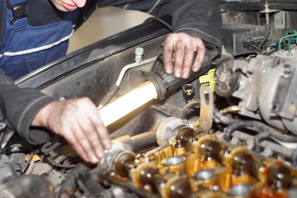 Dirty car mechanic hands examining car automobile at repair service station