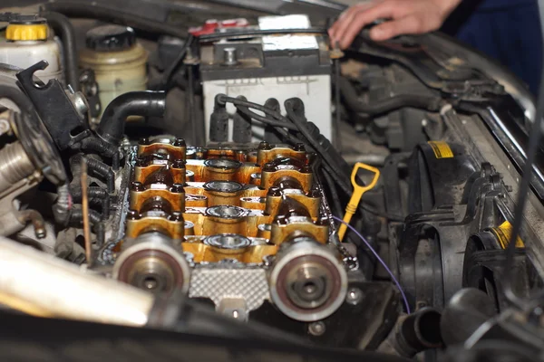 Mechanic hands tighten nut with wrench while repairing engine