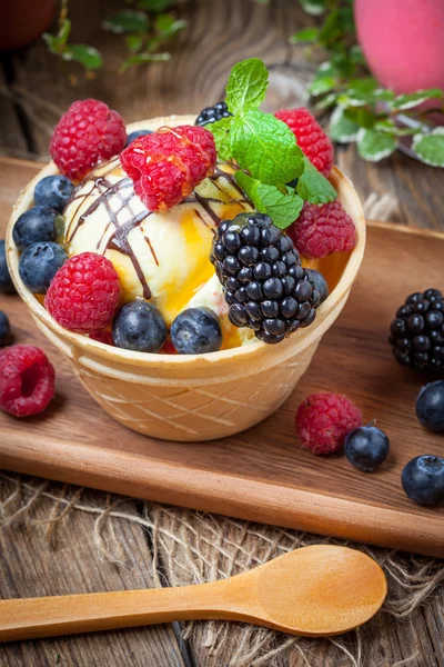 Tasty ice cream dessert with fruit in a waffle bowl.