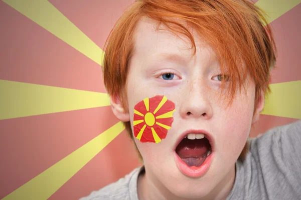 Redhead fan boy with macedonian flag painted on his face