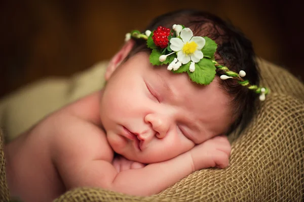 Newborn baby girl has sweet dreams in strawberries