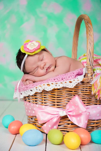 Newborn baby girl  has sweet dreams on the wicker basket. Easter Holiday