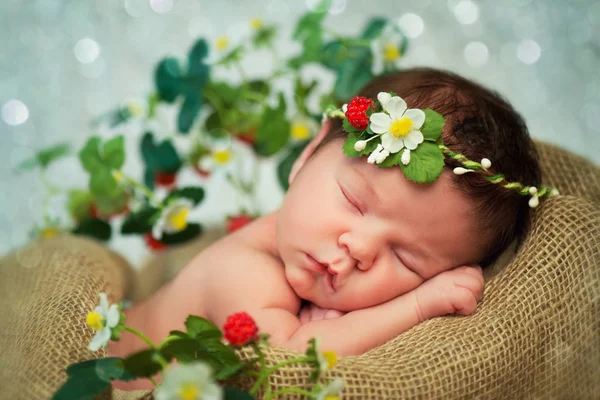 Newborn baby girl has sweet dreams in strawberries