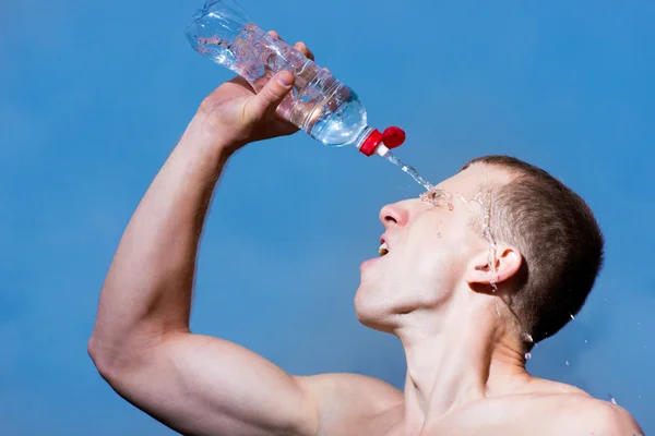 Young tired athlete splashing and pouring fresh water on his head