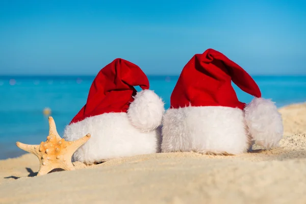 Romantic New Year at Sea. Christmas vacation. Santa hats on sandy beach