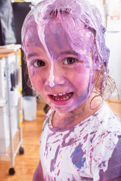 Happy little future artist covered in paint